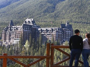 Visitors look over the town of Banff, AB at the Fairmont Banff Springs Hotel in Banff, AB.