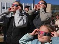 Mom Laura St Croix with daughters Fineley and Zoe are is shown at the University Calgary in Calgary on Monday, April 8, 2024 during an eclipse viewing party. Mom took the kids out of school for this 'once in a lifetime opportunity.'