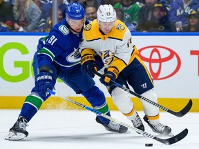 Nikita Zadorov checks Gustav Nyquist of the Predators on Sunday during the Canucks' 4-2 victory in their playoff opener at Rogers Arena.