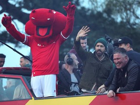 Ryan Reynolds, co-owner of Wrexham, celebrates his team's promotion in 2023 along with his team's mascot, players and staff. The team has been promoted again, this time to League 1, and will play the Vancouver Whitecaps in an exhibition in July.