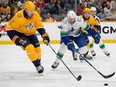 Nashville Predators defenseman Luke Schenn (2) and Vancouver Canucks center Dakota Joshua (81) chase the puck during the first period of an NHL hockey game Tuesday, Dec. 19, 2023, in Nashville, Tenn.