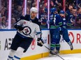 Vancouver Canucks' Teddy Blueger and Phillip Di Giuseppe celebrate Giuseppe's goal as Winnipeg Jets' Nino Niederreiter skates past during the game in Vancouver, Saturday, March 9, 2024.