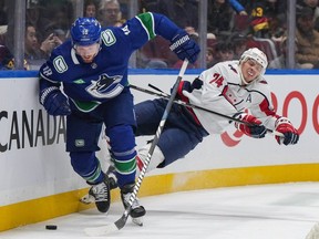 Capitals defenceman John Carlson  is upended by Canucks winger Sam Lafferty during March 16 meeting at Rogers Arena.