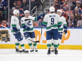 Vancouver Canucks' Carson Soucy, Brock Boeser, J.T. Miller and Pius Suter celebrate a goal against the Edmonton Oilers during second period NHL action in Edmonton, Saturday, April 13, 2024.