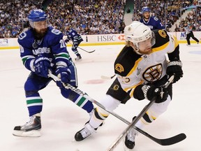Chris Higgins of the Canucks battles with Chris Kelly of the Bruins during Game 7 of the 2011 Stanley Cup final at Rogers Arena.