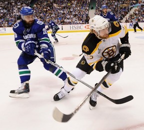 Chris Higgins of the Canucks battles with Chris Kelly of the Bruins during Game 7 of the 2011 Stanley Cup final at Rogers Arena.