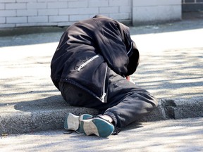 A man lies on the sidewalk in Vancouver's Downtown Eastside on April 18, 2024. (NICK PROCAYLO/PNG)