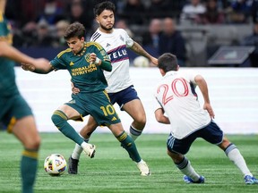 Los Angeles Galaxy's Riqui Puig evades Vancouver Whitecaps' Ryan Raposo in Vancouver April 13, 2024. The Whitecaps dropped a 3-1 decision to the L.A. Galaxy and sit in second spot on the West heading into a rivalry matchup with the Sounders in Seattle this weekend.