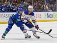 Canucks winger Dakota Joshua pressures superstar Connor McDavid of the Oilers during Game 5 playoff series encounter on May 16 at Rogers Arena.