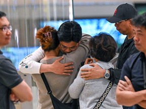 Passengers of Singapore Airlines flight SQ321, which made an emergency landing in Bangkok, greet family members upon arrival at Changi Airport in Singapore on Wednesday.