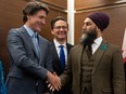 Prime Minister Justin Trudeau shakes hands with New Democratic Party leader Jagmeet Singh as Conservative leader Pierre Poilievre looks on at a Tamil heritage month reception on Jan. 30, 2023, in Ottawa.