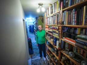 John William, who is losing his sight, poses for a photograph with his collection of books that he has decided to sell, in Vancouver, Wednesday, April 24, 2024.