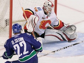Calgary Flames #34 Miikka Kiprusoff makes the save against #22 Daniel Sedin of the Vancouver Canucks during the first period of NHL action at GM Place in Vancouver, B.C., March 14, 2010.