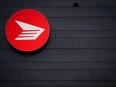 Canada Post says it lost $748 million before tax last year as it warned of larger, unsustainable losses ahead. The Canada Post logo is seen on the outside the company's Pacific Processing Centre, in Richmond, B.C., June 1, 2017.