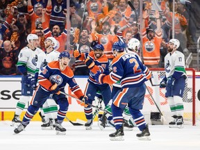 Edmonton Oilers' Evan Bouchard (2), Dylan Holloway (55) and Evander Kane (91) celebrate a goal against the Vancouver Canucks during third period second-round NHL playoff action in Edmonton on Tuesday May 14, 2024.THE CANADIAN PRESS/Jason Franson