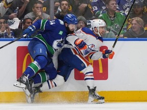 Vancouver Canucks' Phillip Di Giuseppe, left, battles along the boards with Edmonton Oilers' Derek Ryan during the first period in Game 5 of an NHL hockey Stanley Cup second-round playoff series in Vancouver on Thursday, May 16, 2024.