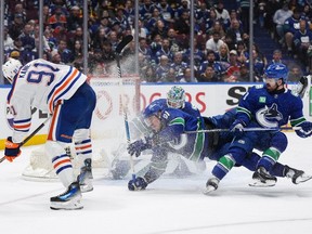 Vancouver Canucks' Conor Garland, front right, and Nikita Zadorov collide after goalie Arturs Silovs, back, stopped Edmonton Oilers' Evander Kane, front left, during the second period of Game 7 on Monday night at Rogers Arena. The Oilers won 3-2.