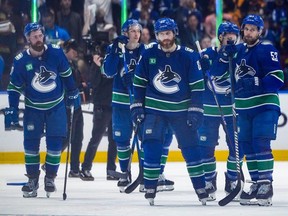Vancouver Canucks' Ian Cole, front centre, Teddy Blueger, front right, Filip Hronek, back left, and Ilya Mikheyev, back second left, stand on the ice after Vancouver was defeated by the Edmonton Oilers 3-2 during Game 7 of an NHL hockey Stanley Cup second-round playoff series, in Vancouver, on Monday, May 20, 2024.