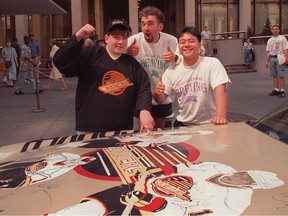 Will Verner (black hat), Derek Mah and Ben Ellison with the CANUCKMOBILE, in front of Madison Square Gardens in New York during the 1994 Stanley Cup.