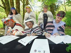 In the front row, left to right, Chief Pahalicktun Richard Thomas (Lyackson First Nation), Chief Sulsulxumaat Cindy Daniels (Cowichan Tribes), and Premier David Eby sign a land-transfer deal at Skutz Falls. In the back row, left to right, are Laxele'wuts' aat Shana Thomas (Lyackson First Nation), Murray Rankin, minister of Indigenous Relations and Reconciliation, and Sunaxwumaat Dana Thorne (Cowichan Tribes).