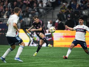 Inter Miami's Robert Taylor, back centre, scores a goal as he takes a shot past Vancouver Whitecaps' Mathias Laborda, right, and Ranko Veselinovic, front left, during the first half of an MLS soccer match, in Vancouver, on Saturday, May 25, 2024.