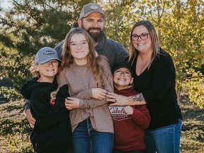 Nine-year-old Carter Vigh, wearing a red sweatshirt, is pictured with his brother Daxton (left), sister Cadence, father James and mother Amber. Carter died of asthma exacerbated by wildfire smoke in July 2023. As wildfires rage in B.C., his family is trying to protect people from poor air quality due to smoke this year.