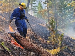 Ashley O'Neil, a member of the Ktunaxa First Nation, puts out hotspots on her job as a wildland firefighter in B.C. on July 8, 2021.