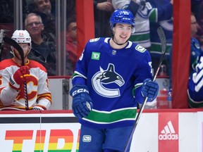 Canucks prospect Aidan McDonough smiles after scoring his first NHL goal against the Flames March 31, 2023.