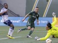Portland Timbers forward Jonathan Rodríguez, centre, scores past Vancouver Whitecaps goalkeeper Yohei Takaoka during soccer match Saturday, June 22, 2024, in Portland, Ore.
