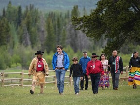 Prime Minister Justin Trudeau, second left, and his son Hadrien, 10, walk with Chief Roger William, left, and Chief Otis Guichon, front right, as they arrive for community celebrations to mark the 10th anniversary of the Tsilhqot'in decision, in Nemaiah Valley June 26, 2024. In 2014, the Supreme Court of Canada granted Tsilhqot'in aboriginal title to more than 1,750 square kilometres of land in the Nemaiah Valley.