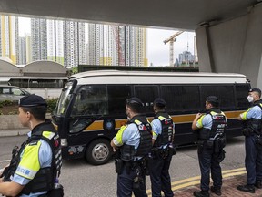Police officers stand guard as a Correctional Services Department vehicle leaves the West Kowloon Magistrates' Courts in Hong Kong, Thursday, May 30, 2024. Fourteen pro-democracy activists were convicted in Hong Kong's biggest national security case on Thursday by a court that said their plan to effect change through an unofficial primary election would have undermined the government's authority and created a constitutional crisis.