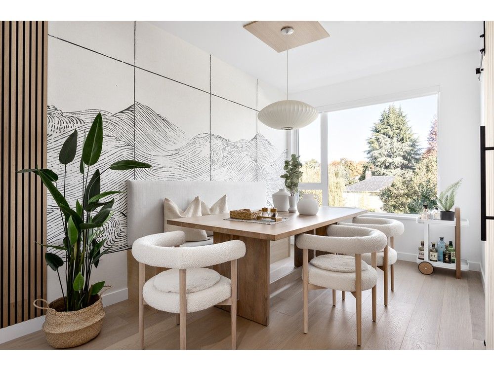 In the dining room, a rectilinear dining table by Mercana complements curvy Mazz Boucle dining chairs by Leanne Ford, from Crate & Barrel. A banquette bench custom-designed by Kalu Interiors maximizes seating in the small space while protecting a linen wallpaper mural – Waves Papyrus by Coordonné (from NewWall).