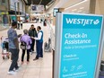 WestJet customers who had flights that were not cancelled check in at the Calgary International Airport following the end of the WestJet mechanics strike on July 1.