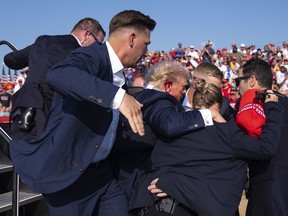 Republican presidential candidate former President Donald Trump is helped off stage by U.S. Secret Service agents at a campaign rally, Saturday, July 13, 2024, in Butler, Pa.