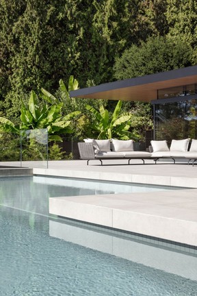 An infinity lap pool with a Baja ledge transitions to porcelain patio tile.