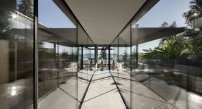 A glass-enclosed walkway leads from the main house to an office, where the owners work from home.