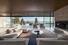 In the living room, a hefty concrete fireplace serves as both focal point and structural support for the home's minimal form.