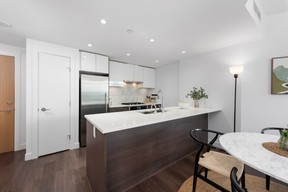 This modern one-bedroom-plus-den suite showcases quartz countertops, breakfast bar seating, air conditioning and stainless-steel Jenn-Air gas appliances,