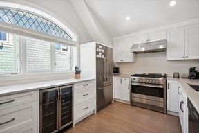 Кухня открытой планировки оснащена бытовой техникой Fisher & Paykel из нержавеющей стали премиум-класса, белой мебелью и кварцевыми столешницами Caesarstone.