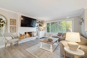 A bright and inviting living room features a wood-burning fireplace and plenty of space to relax.