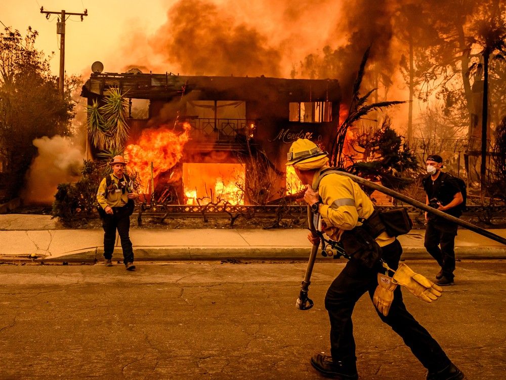  Firefighters work the scene as an apartment building burns during the Eaton fire in the Altadena area of Los Angeles County, California on Jan. 8, 2025.