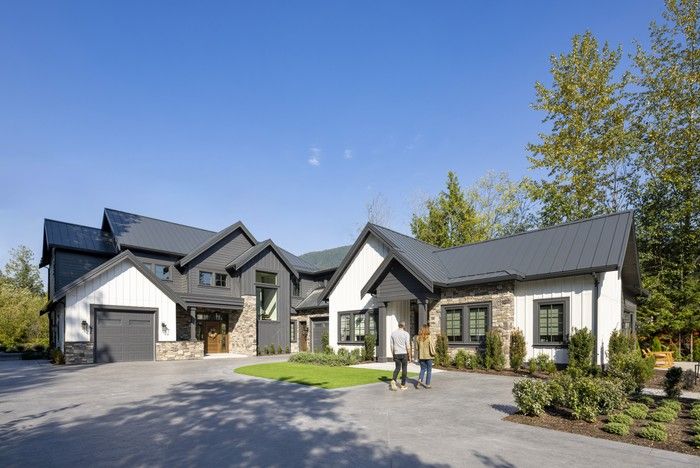  The 5,440-square-foot custom home consists of a main wing and a 948-square-foot connected in-law suite. Stonework, board-and-batten cladding and a metal roof create a modern-farmhouse look.