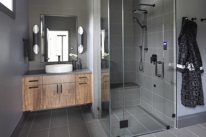  To satisfy the couple’s differing tastes, the design team created his-and-hers ensuites; his with dark, moody tones and a urinal — and hers with layered whites and soft greys.