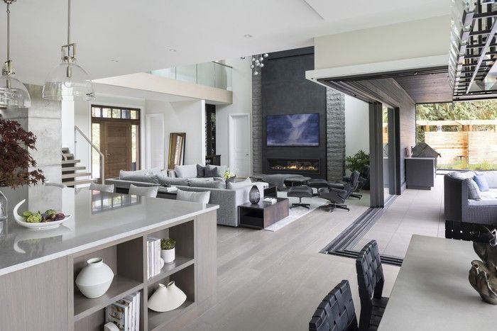  Clever engineering — and hidden steel beams — allows glass doors to roll open from a corner of the living room to an L-shaped patio.