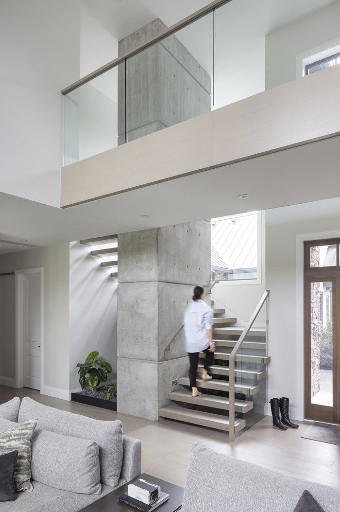  Cantilevered stairs wrap around a concrete column, leading to a 22-foot bridge that overlooks the home’s great room, while keeping the space open and airy.
