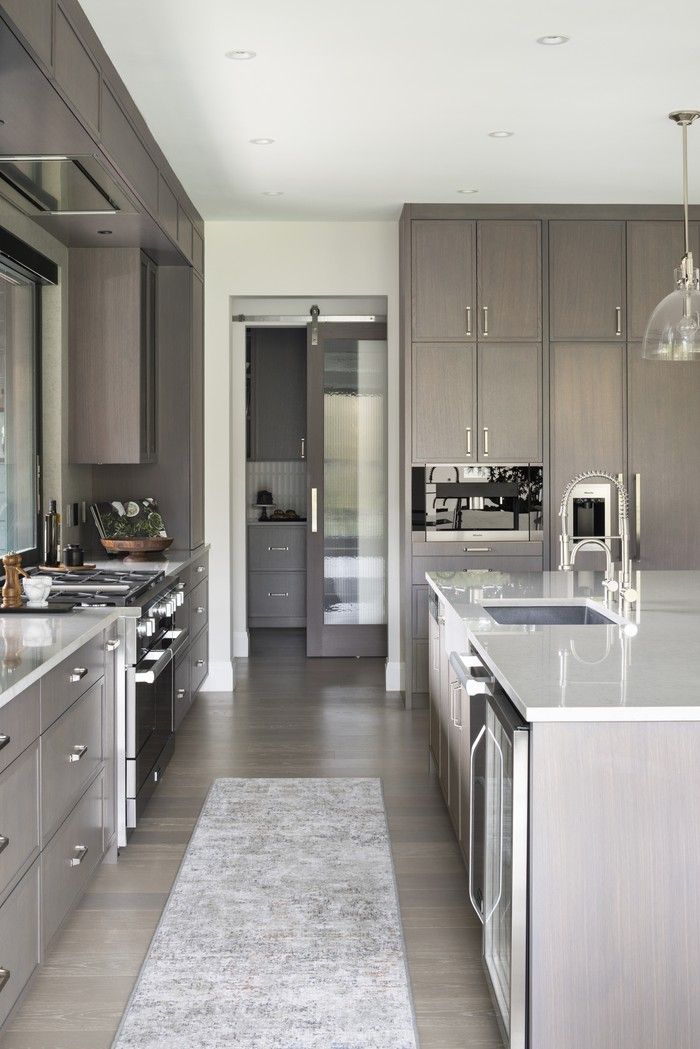  In the kitchen, oak cabinets stained grey-brown complement quartz countertops, Miele appliances, a coffee station, a large butler’s pantry and other luxury touches, such as a built-in vacuum sealer — for the owners, who love to cook sous-vide.