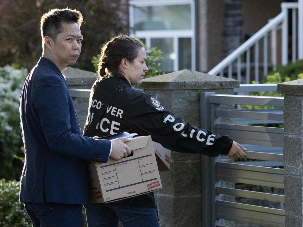 Vancouver Police officers at the house where the accused in Saturday's attack that left 11 dead had lived. Officers searched the house Sunday.