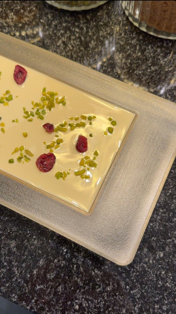  A custom chocolate bar featuring pistachio and dried cranberry in white chocolate made at Max Chocolatier.