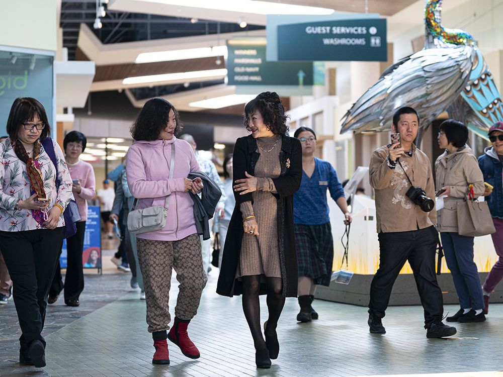 Weihong Liu (centre) walk through the Tsawwassen Mills Shopping Mall in Delta, B.C., May, 18, 2025. Liu has bid to acquire Hudson’s Bay stores in Canada. Weihong Liu (centre) walk through the Tsawwassen Mills Shopping Mall in Delta, B.C., May, 18, 2025. Liu has bid to acquire Hudson’s Bay stores in Canada.