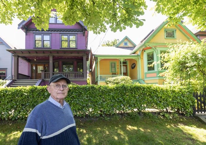   John Davis avec deux des maisons que sa famille possède dans le bloc 100 de West 10th Avenue à Vancouver.